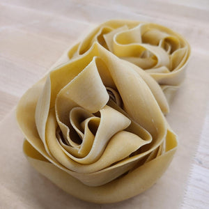 nest of pappardelle pasta. fresh pasta. pappardelle long noodles
